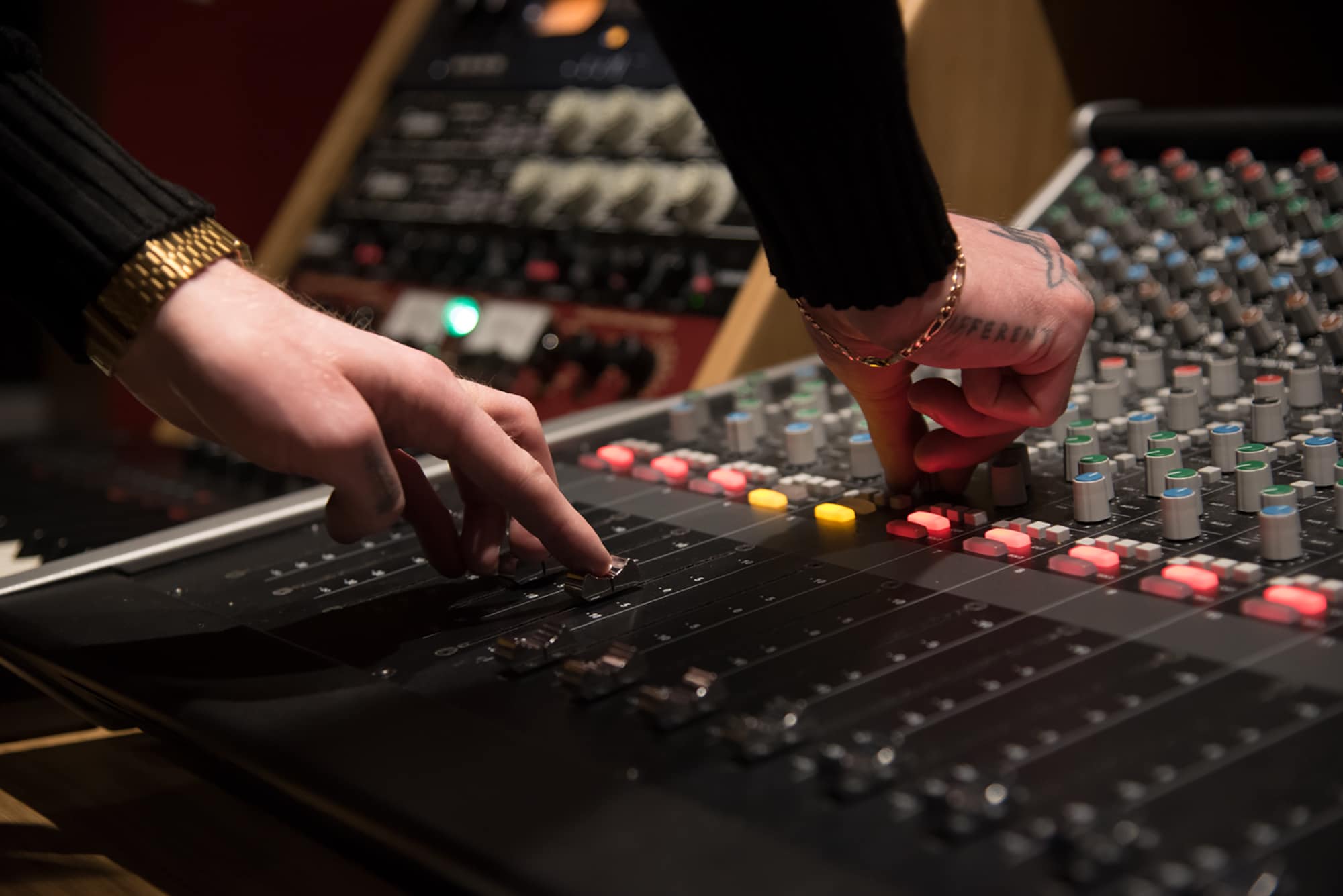 Student using the dials on a Music Production mixer